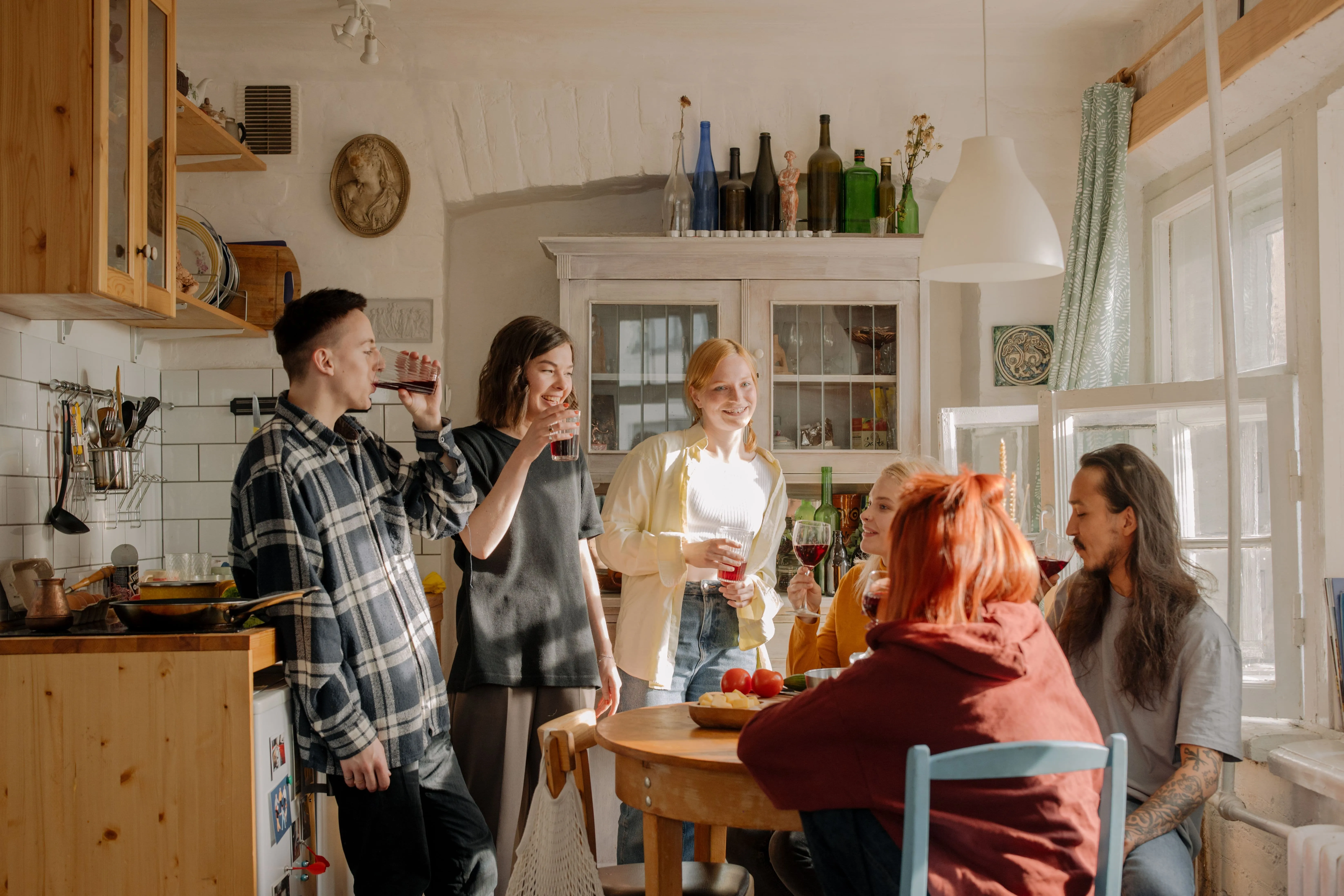 Amigos preparando y compartiendo una cena en casa